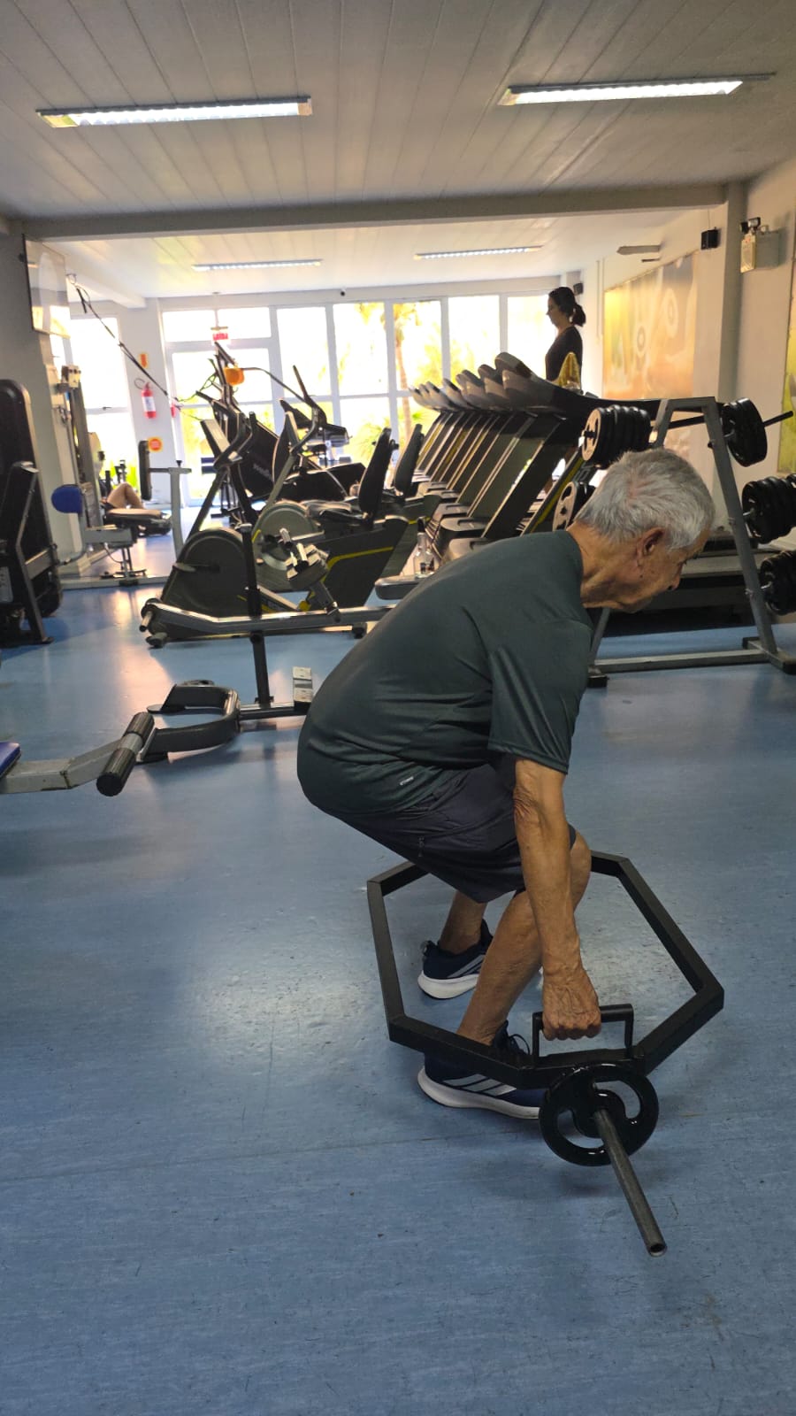 Aluno idoso treinando com orientação